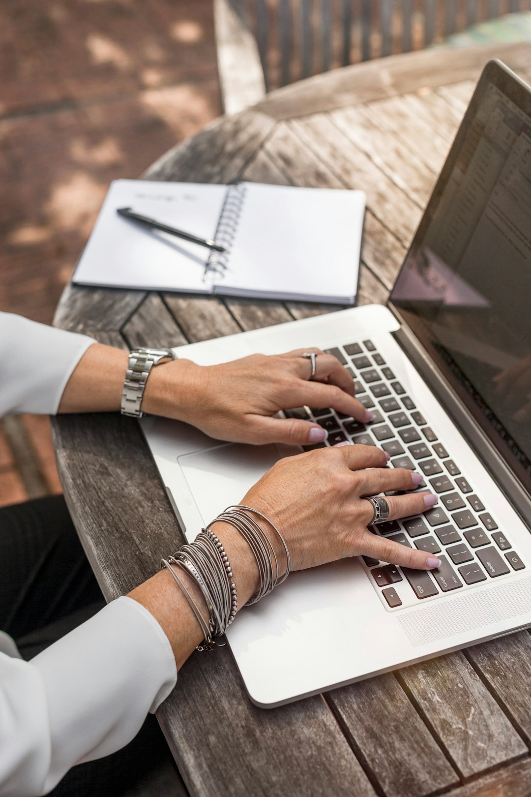 Background: The Evolution of Laptop Backpacks by Backpack Brands person typing on MacBook Pro on brown wooden table during daytime photo