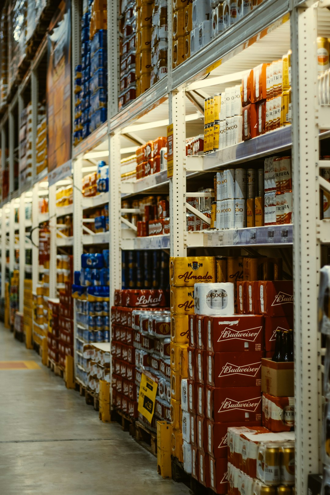Beer shelves by Backpack Brands red and white labeled cans on shelf